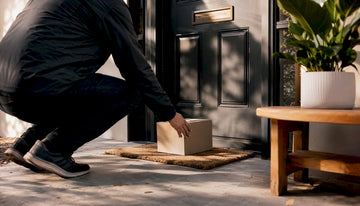 Delivery person placing parcel on doorstep