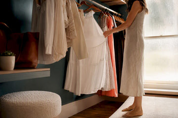 Hands selecting timeless wardrobe staples on rack